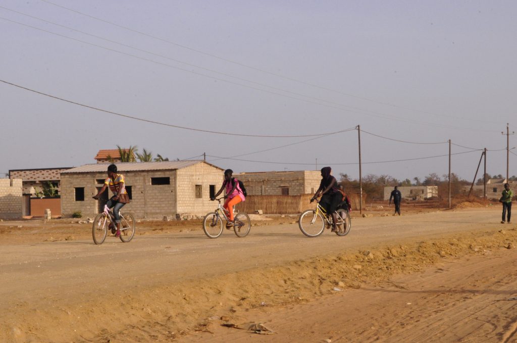 Niños en bicicleta yendo al colegio en Senegal